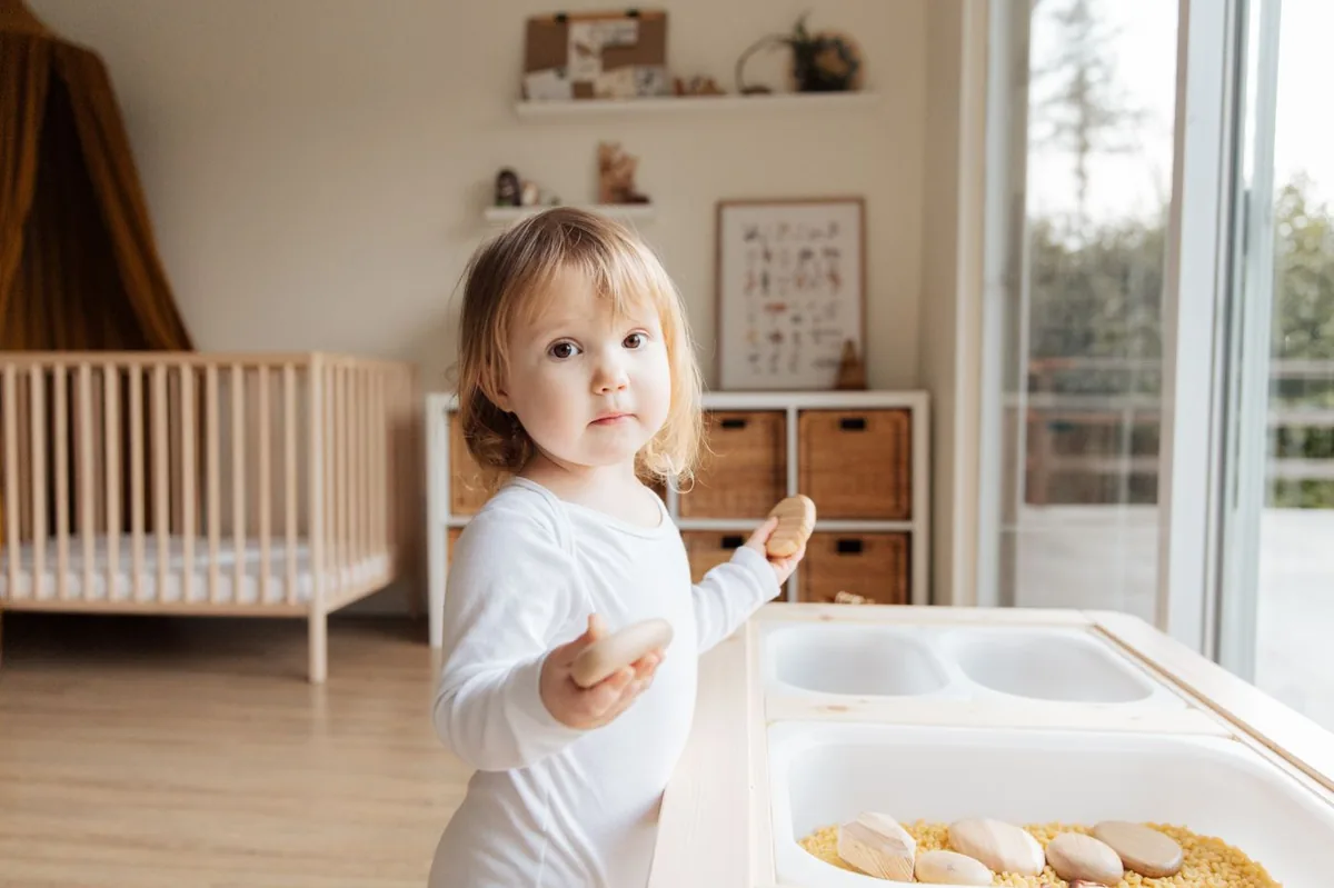 Kleinkind am Spieltisch in einem gemütlichen, hellen Kinderzimmer