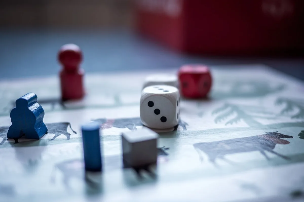 Nahaufnahme von Würfeln und Spielfiguren beim Gesellschaftsspiel